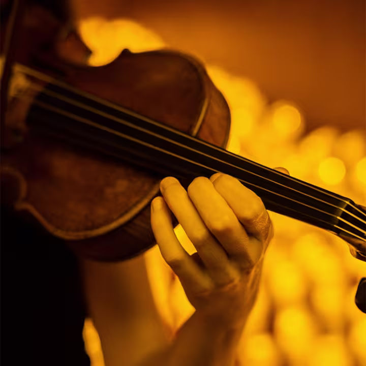 Violinist performing by candlelight