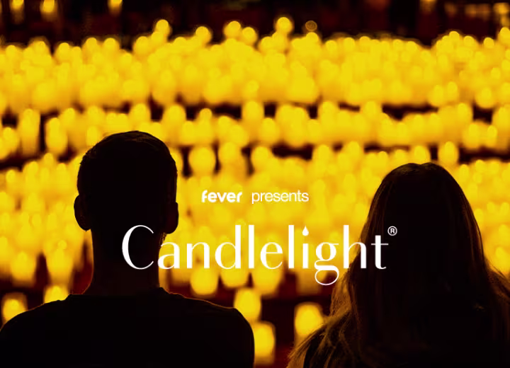 Two people watching a Candlelight concert amid hundreds of glowing candles